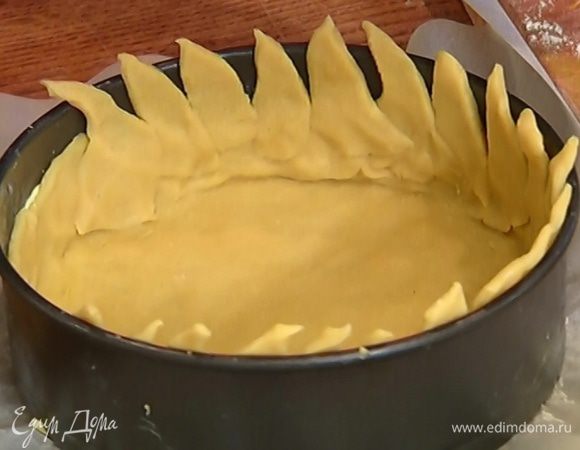 Оставшееся тесто раскатать в тонкий пласт, нарезать небольшими лепестками в форме полумесяцев, можно неровными. Уложить лепестки теста на стенки формы и плотно прижать. Форму с тестом отправить в морозильник на 20 минут.