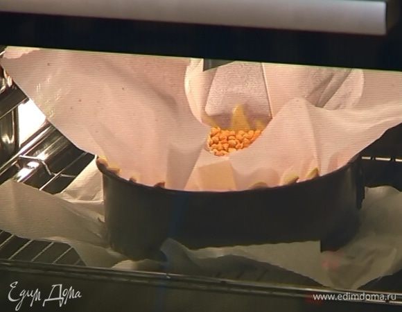 Закрыть охлажденное тесто пекарской бумагой, насыпать сверху горох или бобы и выпекать в разогретой духовке 20 минут, затем бобы с бумагой убрать.