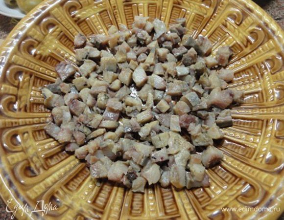 Сельдь очистить и разделать на филе без кожицы и косточек. Нарезать кубиками. Уложить на дно салатного блюда.