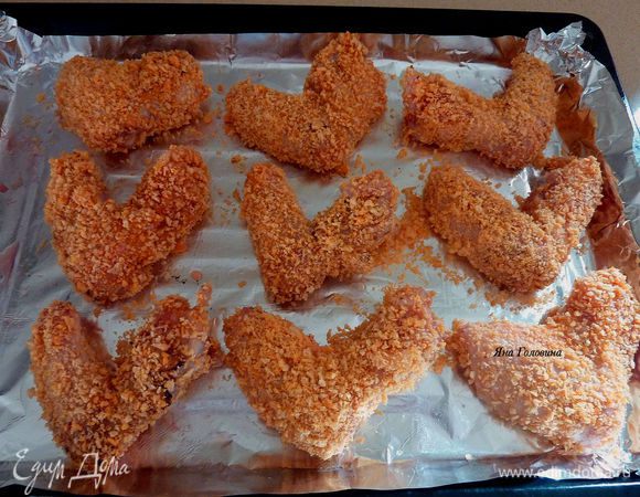  Сложить на  противень застеленный бумагой для выпечки или фольгой . Аккуратно кисточкой смазать крылья оливковым маслом . Запекать крылья в разогретой на 200 гр духовке, 15 минут .

