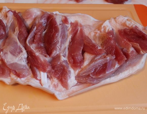 Рульку моем, зачищаем шкурку. Разрезаем и удаляем кость. Мясо слегка отбиваем. Лишнее мясо можно срезать, чтобы легче было свернуть рульку. Солим, перчим и натираем выдавленным чесноком.