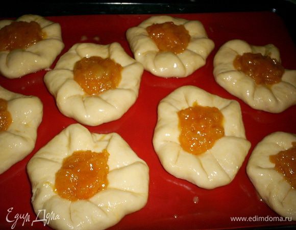 Подошедшие булочки смазываем желтком со столовой ложкой холодной воды. Наполняем серединки розанчиков любым густым джемом или повидлом. Я использую абрикосовые пресервы из кураги http://www.edimdoma.ru/retsepty/60120-domashnie-preservy-iz-kuragi , так как они абсолютно не вытекают и отлично держат форму при выпечке.