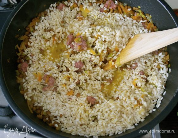 Когда вся жидкость практически выпариться, всыпать рис. Перемешать. И готовить все еще около 15-18 минут (зависит от используемого сорта риса), добавляя понемногу оставшийся горячий (!!!) бульон и доводя ризотто до готовности. 