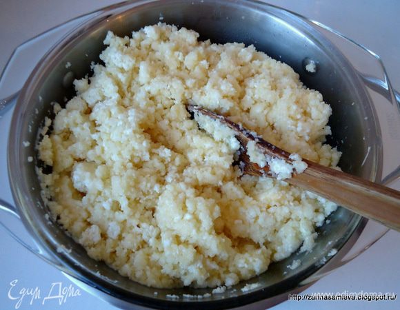 В другую кастрюлю большего диаметра налить воды, поставить на огонь, дать закипеть.
Творог и другие ингредиенты перемешать и поставить на паровую баню. Варить 3-5 минут, постоянно перемешивая. Как только творог начнет плавиться и превращаться в сыр, т.е. тянуться, убрать кастрюлю с паровой бани. 
