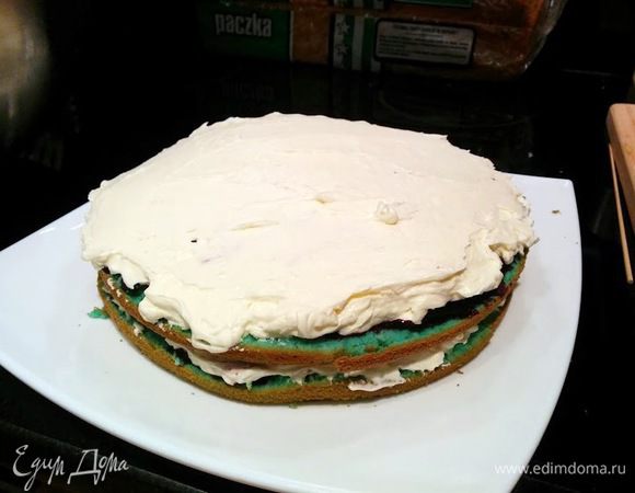 Пока коржи на пропитке, готовим крем - в холодной металлической миске взбиваем сливки и сахарную пудру до пены, затем добавляем маскарпоне и взбиваем еще 10-15 секунд.  Берем 1/3 крема и выкладываем на первый корж, затем поверх второго.