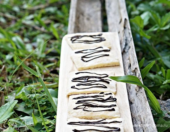 Отрезать в пакете уголок и нанести полоски шоколада на печенье. Охладить 20 минут в холодильнике.