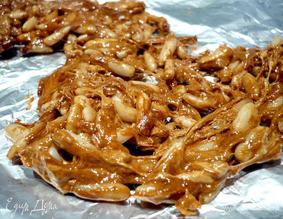 Сахар растопим вместе со щепоткой соли в сотейнике (лучше топить сахар на медленном огне) и добавим соду, доведем до поднятия пены и вмешаем кедровый орех. Снимем с огня. Разровняем карамель на смазанной оливковым маслом фольге. 