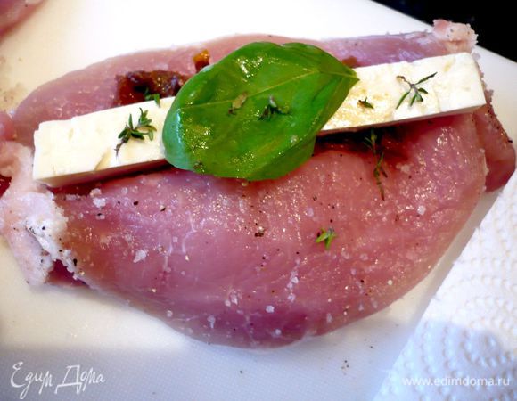 В это время свиные отбивные (у меня 6 штук) промоем, обсушим бумажным полотенцем, посолим, поперчим и аккуратно срежем косточку. У каждой отбивной прорежем сбоку карман.  Нафаршируем каждую отбивную кусочком феты, помидорами, листиком базилика и листиками тимьяна. 