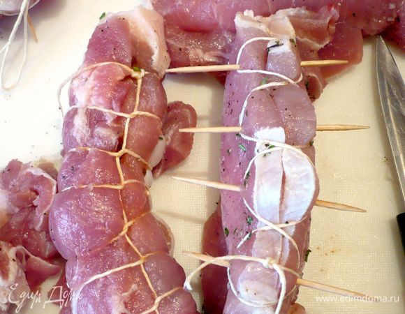 Закрепим каждый карман зубочистками и прихватим кулинарной нитью, проводя нить под шпажкой и перекрещивая ее перед следующей шпажкой (как показано на фото). Если отбивная при надрезании кармана порвалась, можно просто обхватить ее полностью кулинарной нитью, у Вас получится почти рулет.  