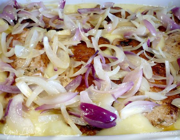 Выложим пюре в смазанную сливочным маслом форму для запекания, сверху — свиные отбивные (сначала вынем из них шпажки и удалим кулинарную нить) и лук. Запекаем в течение 15 минут. 