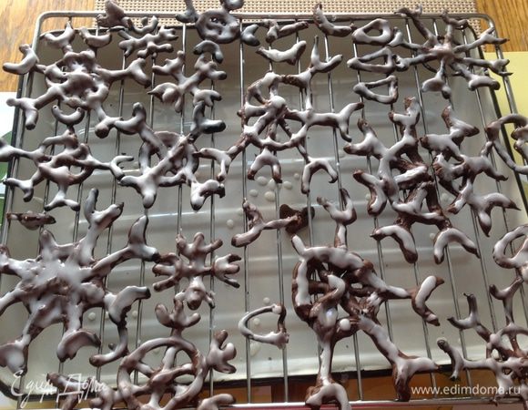 Готовим глазурь: смешиваем сахарную пудру с лимонным соком, подливая лимонный сок понемногу в пудру постоянно хорошо растирая, чтобы глазурь была достаточно густой, но наносилась кисточкой на снежинки.
Покрываем все снежинки глазурью и опять оставляем их сохнуть на решетке. 