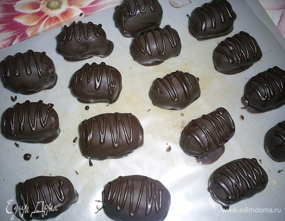 Набираем примерно полстоловой ложки пралине, расплющиваем на ладони в лепешку, кладем посредине зернышко миндаля в карамели и формируем конфетку слегка вытянутой формы. Заготовки отправляем в холодильник примерно на час, чтоб они затвердели. Затем можно обкатать конфеты в какао-порошке (как в оригинале) или окунуть в растопленный темный шоколад (как на фото).