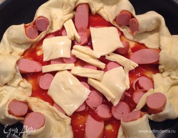 Смазать основы томатным соусом. Выложить сосиски.