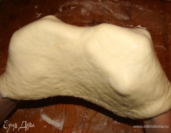 Надо сделать так, чтобы в центре тесто было тоньше чем по краям, для этого поместить его на кулачки и перемещая, оно вытянется.