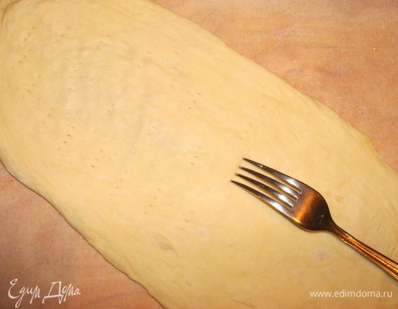 Противень застелить пекарской бумагой, смазать ее маслом растительным. Выложить нашу заготовку для пиццы. Центральную часть, куда будет выкладываться начинка, придавить пальцами и можно проткнуть вилочкой в некоторых местах, если добиваться особо тонкого теста.