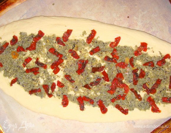 Разложить кусочки помидорок. Боковые слегка вдавить в тесто.