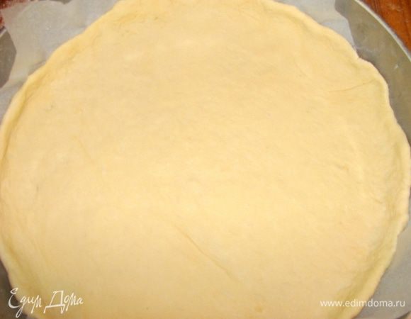 Форму для выпечки заселить пекарской бумагой. Тесто раскатать до нужного диаметра и поместить в форму так, чтобы края немного поднимались к верху, т.к. сыра в этой пицце довольно много и ему не нужно вытекать за определенные рамки)))