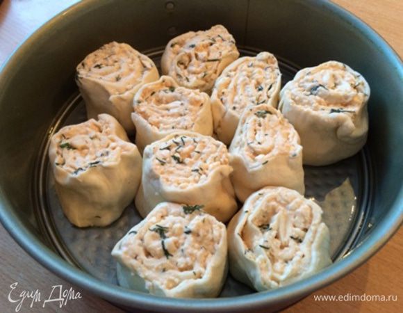 Свернуть тесто в рулет. Порезать на куски 4-5 см. Смазать форму и выложить кусочки рулета вертикально, не слишком плотно.