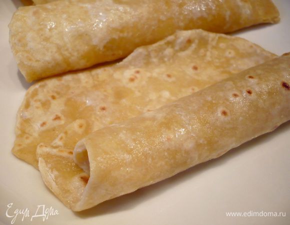 Выкладываем лепешку на блюдо и сразу сворачиваем ее, неплотно, просто чтобы она приобрела форму рулета. Так же поступаем с остальными лепешками, выкладывая их к предыдущей лепешке, но не прижимая слишком. Когда лепешки подстынут (минут через 10) стоит немного отвернуть край лепешки, как бы приоткрыть ее (я этого не сделала и, когда спустя полчаса начала наполнять их начинкой, края у некоторых из них немножко склеелись и рвались при разворачивании). 