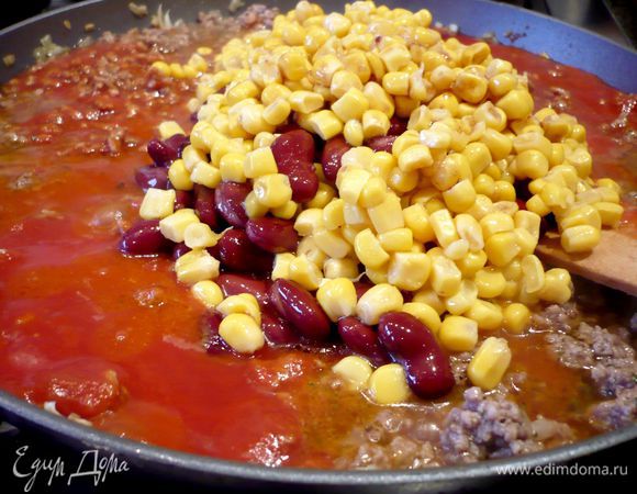 Добавим пассерованные томаты, сладкую кукурузу и фасоль (сначала их необходимо откинуть на сито, чтобы стекла жидкость), добавляем 1 ст.л. майорана, солим и перчим.