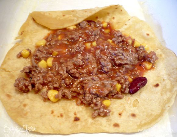 Начиняем каждую лепешку начинкой, сворачиваем в рулет, так поступаем со всеми остальными лепешками, выкладывая их плотным рядком. Если начинка у Вас осталась, просто добавьте ее в форму по краям лепешек. 