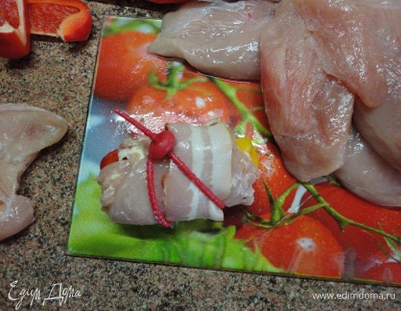 2.  Рулетики свернуть, обернуть полосками бекона и скрепить.