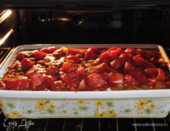 2. Сладкий перец нарезать кубиками. Лук и чеснок очистить и порубить. Маслины откинуть на дуршлаг, разрезать на половинки и вместе с чесноком, сладким перцем и луком выложить к куриным ножкам. Туда же добавить консервированные томаты вместе с соком, предварительно измельчив их. Влить красное вино. Посолить, поперчить и посыпать оставшимся сушеным базиликом. Блюдо поместить в духовку еще на 30 минут.