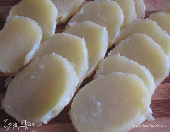 Картофель отварить до готовности. Остудить и нарезать кружочками. Петрушку и чеснок измельчить.