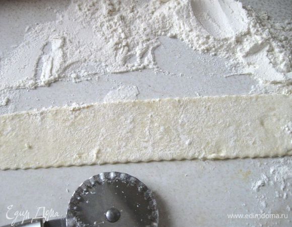 Вынуть тесто из холодильника. Разделить тесто на части, раскатать, присыпая мукой. Нарезать ножом для пиццы на полоски шириной 7 см. 