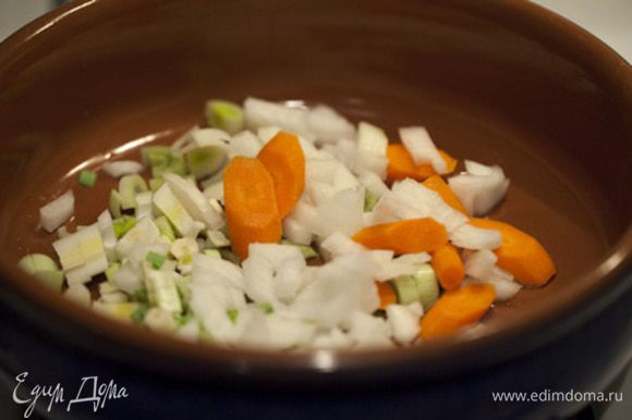 Разогреваем 2 столовые ложки оливкового масла в суповой кастрюле и припускаем морковь, лук-порей, лук и чеснок в течение 5 минут. Добавляем помидоры, чечевицу, тмин, порошок карри и продолжаем обжаривать еще 3 минуты, помешивая. Вливаем овощной бульон, даем супу закипеть, и варим на среднем огне 20 минут.