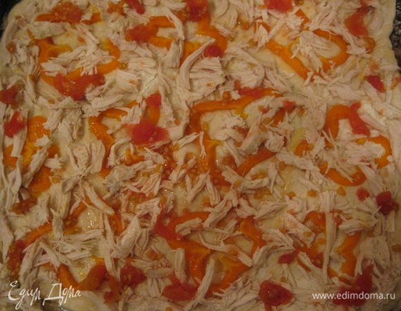 Нарезаем вареную курицу длинными ломтиками. Снять кожуру с консервированных помидор и распределить их на пицце по бокам.
Сверху посыпать тертым сыром. Выпекать 15-20 минут.