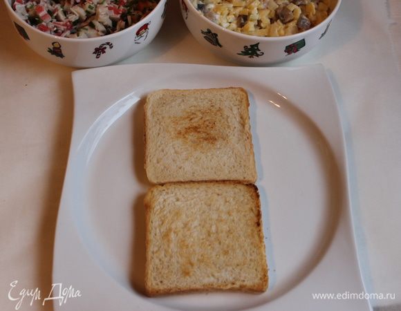 Хлебные тосты обжарим на сухой сковородке или в тостернице. Выкладываем 2 штуки на блюдо.Если у вас будут большие куски хлеба, то можно обрезать его по бокам.