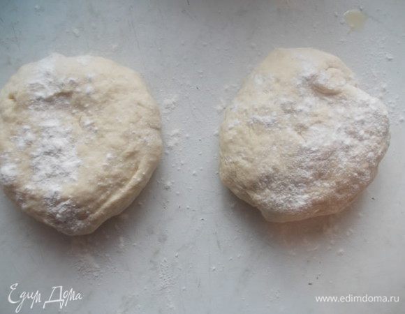 Добавить оливковое масло и муку, замесить тесто. Разделить его на две части и накрыть полотенцем. Оставить его в покое.