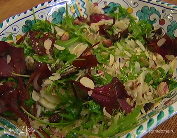 Выложить рис со сковороды на тарелку, добавить салатные листья, посыпать зеленью фенхеля, миндальными хлопьями и фисташками.