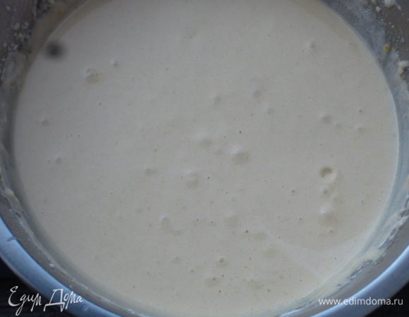 Не прекращая взбивать, постепенно ввести сахар. Добавить йогурт, муку с разрыхлителем, растительное масло и ещё раз взбить до получения однородного теста.