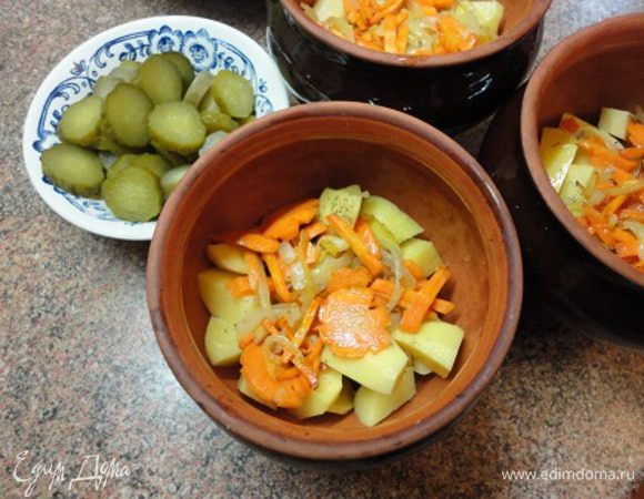 Включить духовку для разогрева до 200 градусов. Картофель очистить, нарезать небольшими кусочками и уложить на дно горшочка. Сверху выложить жареные лук с морковью. В каждый горшочек долить примерно по полстакана воды, накрыть и поставить в духовку на 20 минут.