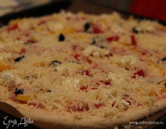 Посыпать пиццу сырной смесью и кунжутным семенем.