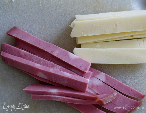 Первым делом яйца отварить вкрутую. Остудить и очистить.
Колбасу мортаделла, сыр и сало (я не использовала!) нарезать достаточно тонкими полосками-брусочками.