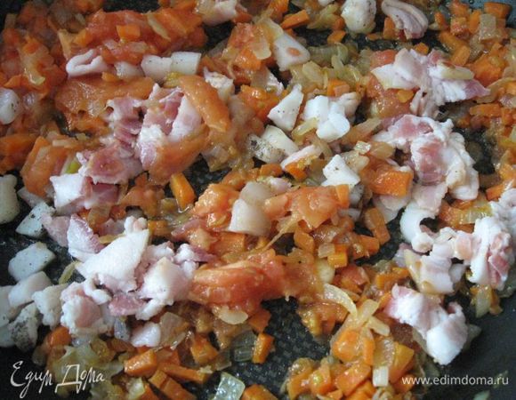 Добавить морковь, продолжать обжарку, добавить  сало, бекон, порезанные помидоры.