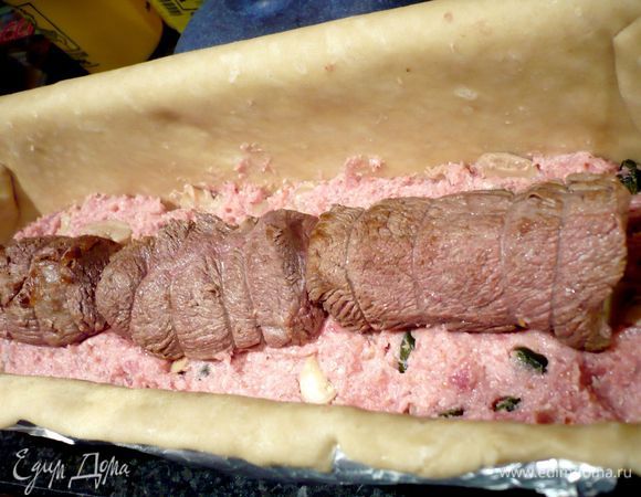 Теперь заполняем нашу форму 1/3 частью начинки. Сверху посередине выкладываем вдоль сначала одну часть телятины (кулинарную нить с кусочков нужно снять) и сразу за ней впритык вторую часть. У меня второй кусочек оказался широковат, я его разрезала вдоль. Так что получилось три кусочка. Заполняем форму остальной начинкой. Разравниваем начинку рукой.