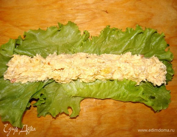 Выложить сырную начинку ложечкой, свернуть в рулетик.