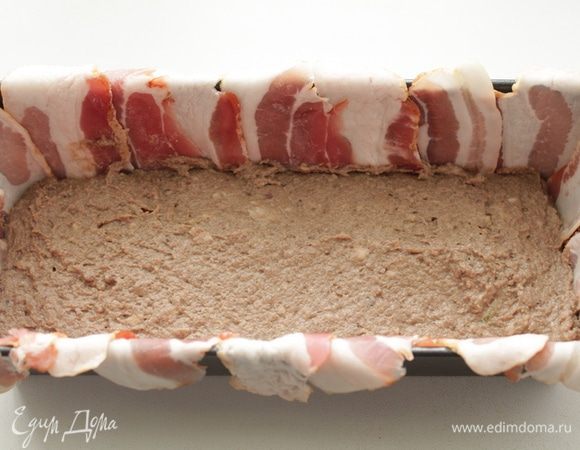 Стенки формы выложить тонкими пластинами свиного бекона. (можно сделать и без бекона)
Укладываем часть фарша и печени на дно формы.