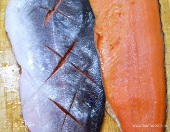 Я взяла форель весом 800 г. Рыбку, конечно, можно купить и побольше. Просто гостей мы с мужем не ждали, а нам и такая – в самый раз!
Форель была уже потрошенная, муж просто очистил ее от чешуи, разрезал вдоль хребта, удалил хребет, реберные косточки, хвост, плавники (кому же, как не заядлому рыбаку, заниматься разделкой рыбы!).
На коже одного филе острым ножом сделать глубокие надрезы.
