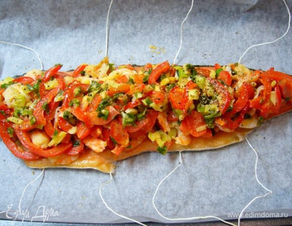 Духовку разогреть до 220С.
Форму застелить пергаментом. Выложить на пергамент 4 длинных отрезка кулинарной нити.
Уложить половинку рыбы (без надрезов) кожей вниз. Приправить специями для рыбы.
Распределить начинку. Поперчить.
