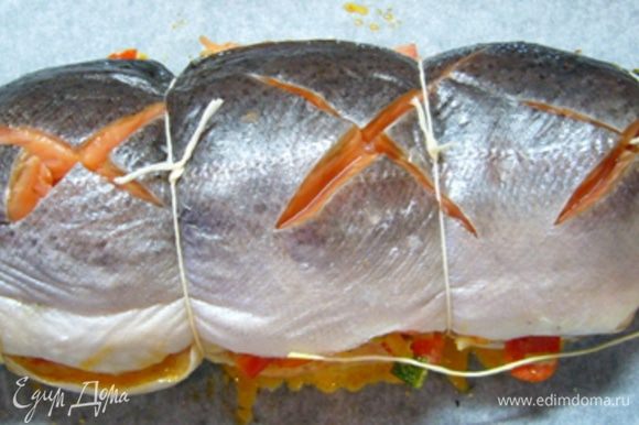 Накрыть вторым куском рыбы, соединить концы кулинарной нитью. Поместить рыбу в духовку на 15 мин.