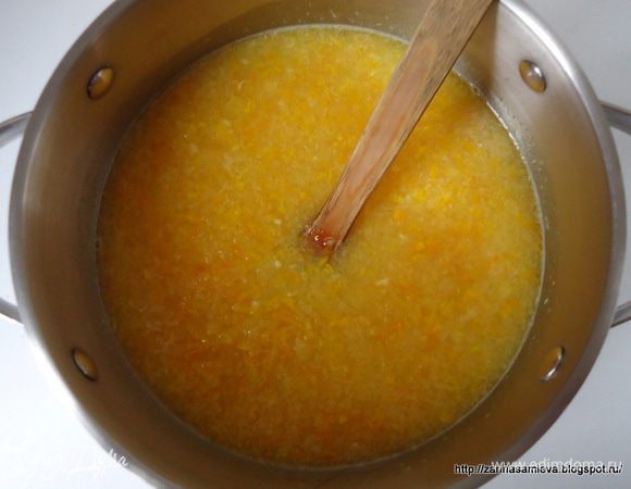 Измерить количество выжатого сока, у меня получилось 450 мл. В кастрюле смешать апельсиновый сок с 700 мл воды. Туда же добавить цедру, измельченный жмых и косточки от цитрусовых. Поставить кастрюлю на огонь и после закипания немного убавить огонь. Уваривать в течение 30 минут. 
