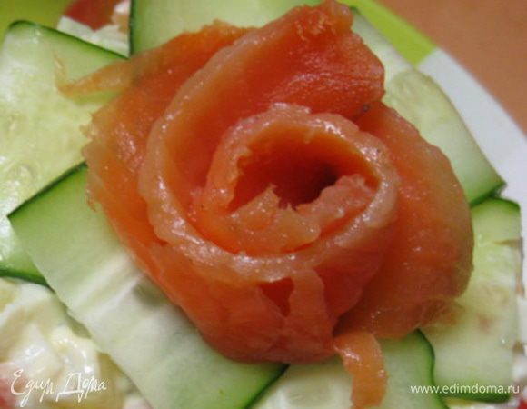Нарезать тонкими пластинами семгу и сформировать из нее «розочку». Для этого: разложить кусочки семги внахлест в виде ленты, а затем свернуть их в рулончик. С одного края рулончика сделать небольшие надрезы (около 1 см) и немного вывернуть «лепестки».