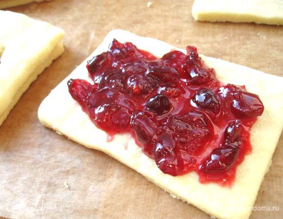 На целые половинки нанести слой начинки (черничное и клюквенное варенье)  и накрыть оставшимися печеньями с вырезанной серединкой. 