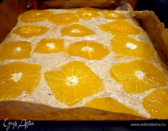 В застеленную бумагой для выпечки форму (у меня прямоугольная, также подойдет и круглая форма диаметром 26 см) выложим тесто, разровняем. Каждый ломтик апельсина опустим в сироп и выложим на тесто. Пирог поставим в духовку на 40 — 45 минут.