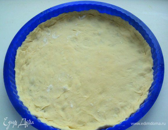 Тесто раскатать в круг толщиной 26 см, уложить в форму для пиццы.